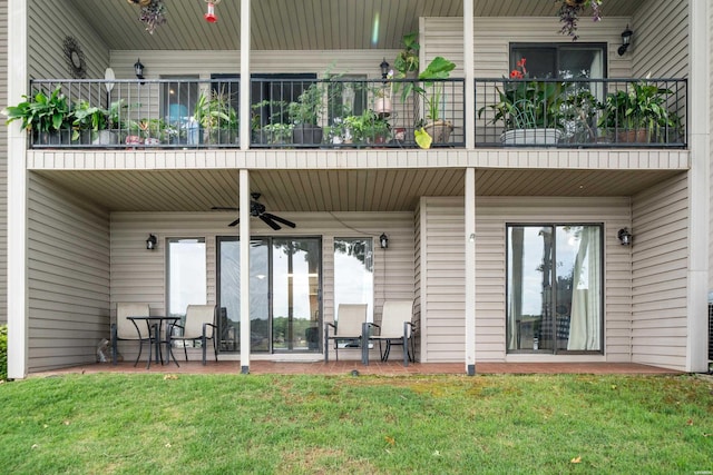 rear view of house with a lawn, a patio area, a balcony, and a ceiling fan