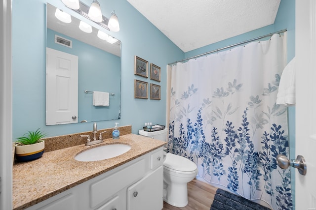 full bath with visible vents, toilet, wood finished floors, a textured ceiling, and vanity