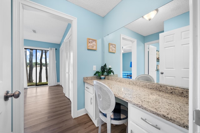 bathroom with vanity, baseboards, a textured ceiling, and wood finished floors