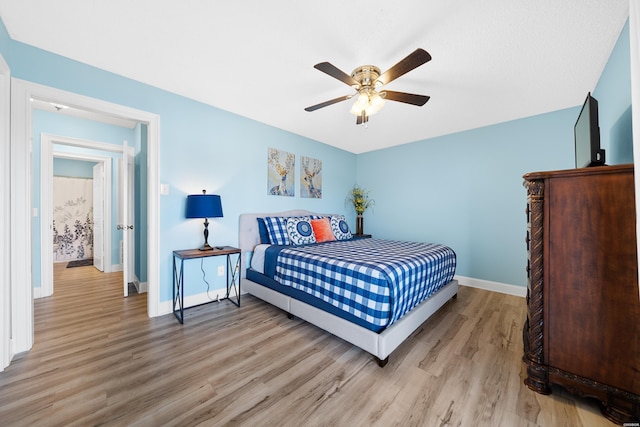 bedroom with light wood-style floors, ceiling fan, and baseboards