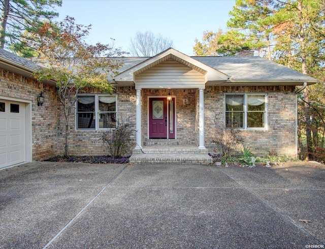 view of front of house with a garage, a shingled roof, a chimney, and brick siding