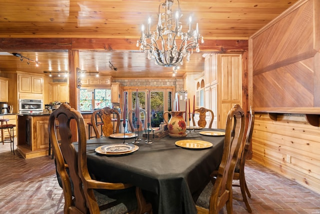 dining space featuring brick floor, wooden ceiling, a notable chandelier, and wood walls