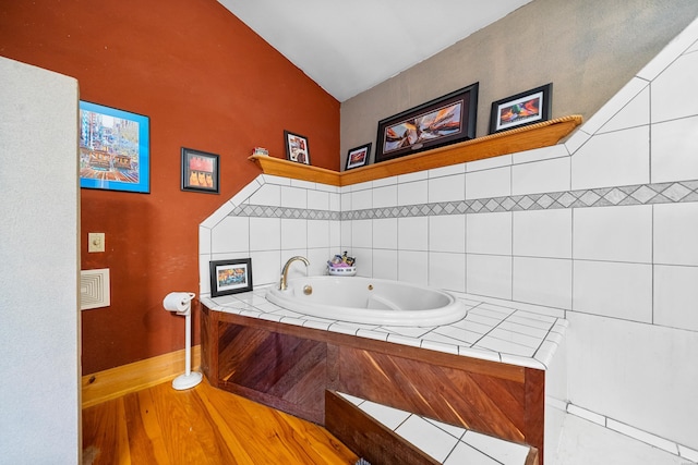 bathroom featuring a whirlpool tub and wood finished floors