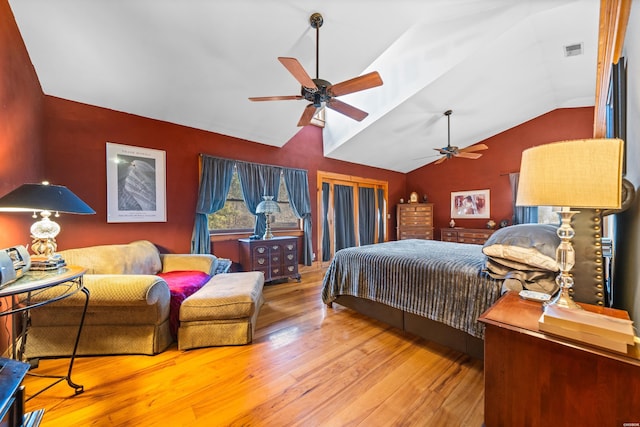 bedroom with lofted ceiling, visible vents, ceiling fan, and wood finished floors