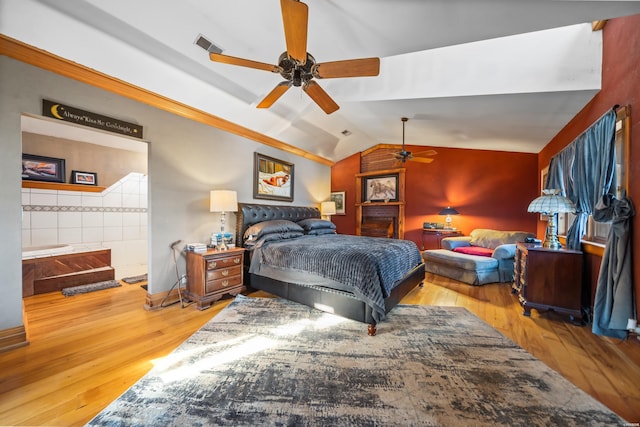 bedroom featuring lofted ceiling, a ceiling fan, visible vents, and wood finished floors