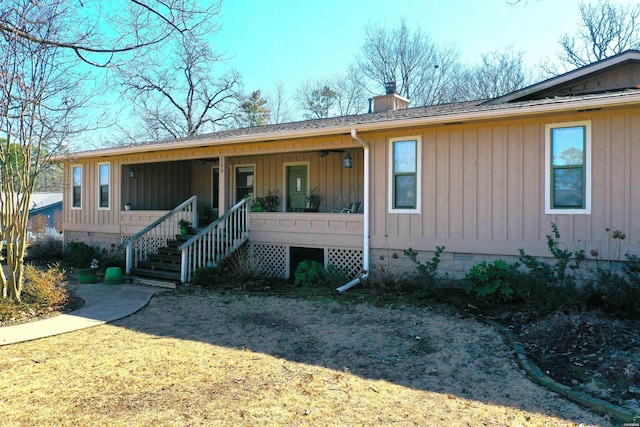 view of front facade with covered porch, roof with shingles, stairway, crawl space, and a chimney