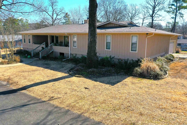 exterior space featuring stairs, a chimney, and a front yard