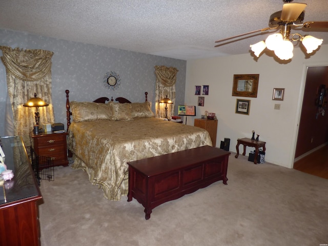 carpeted bedroom with a textured ceiling, a ceiling fan, and wallpapered walls