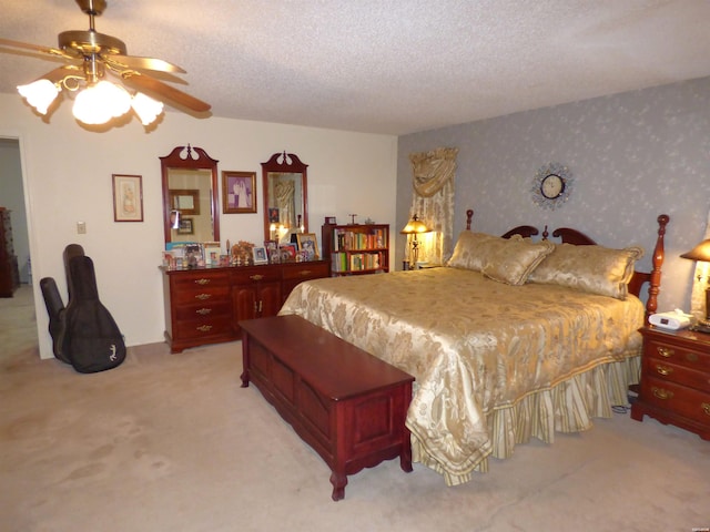 bedroom featuring light colored carpet, ceiling fan, a textured ceiling, and wallpapered walls