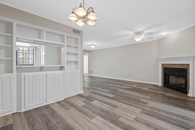 unfurnished living room with crown molding, a fireplace, visible vents, wood finished floors, and baseboards