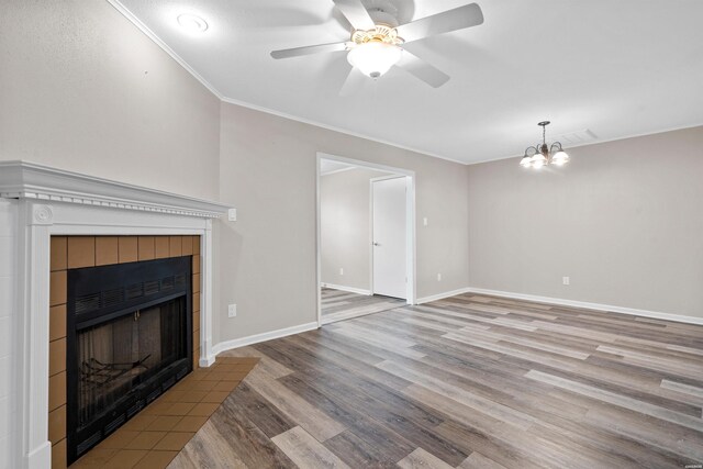 unfurnished living room featuring light wood-type flooring, baseboards, ornamental molding, and a tiled fireplace