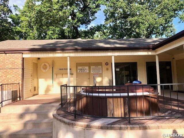 exterior space featuring brick siding and a jacuzzi