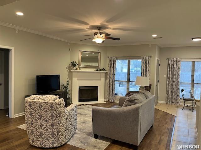 107 Legacy Ln, Hot Springs, AR 71901 - living room with a fireplace with flush hearth, crown molding, baseboards, and ceiling fan