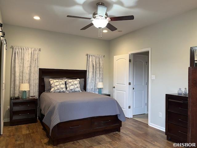 107 Legacy Ln, Hot Springs, AR 71901 - bedroom featuring dark wood-style floors, a barn door, recessed lighting, and baseboards