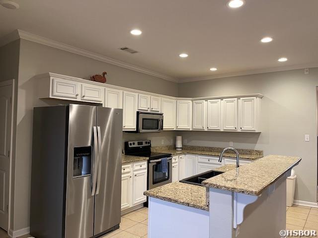 107 Legacy Ln, Hot Springs, AR 71901 - kitchen featuring light tile patterned floors, white cabinets, appliances with stainless steel finishes, light stone countertops, and a sink