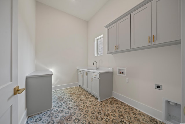washroom with cabinet space, a sink, electric dryer hookup, and baseboards