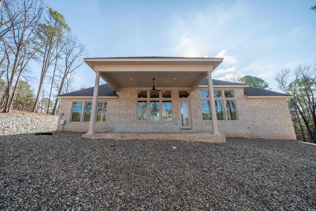 rear view of house featuring ceiling fan, brick siding, and a patio area