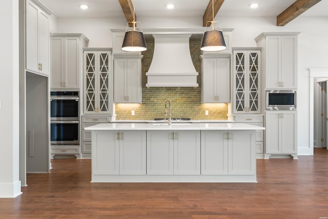 kitchen featuring hanging light fixtures, custom range hood, stainless steel appliances, and light countertops