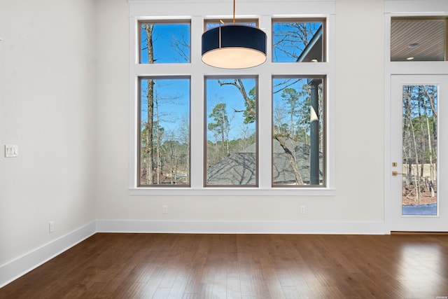 interior space with baseboards and dark wood-style flooring