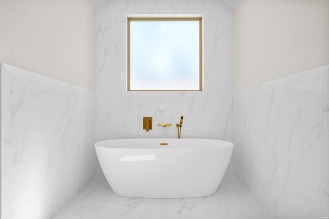 full bath with a freestanding tub and marble finish floor