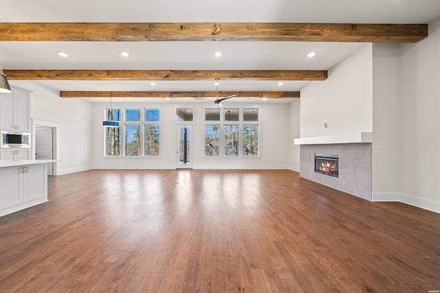 unfurnished living room with baseboards, a fireplace, and a healthy amount of sunlight