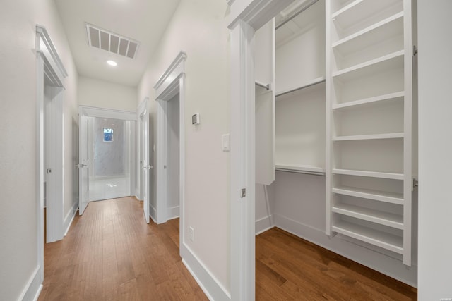corridor with recessed lighting, wood finished floors, visible vents, and baseboards