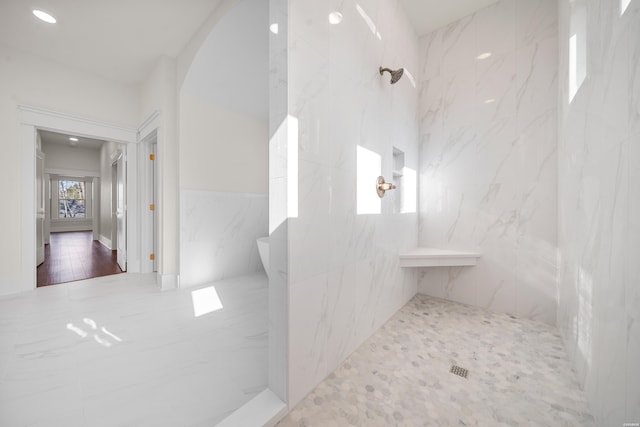 bathroom featuring a marble finish shower