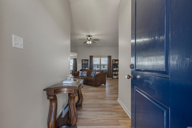 entryway with light wood-style flooring, baseboards, and ceiling fan