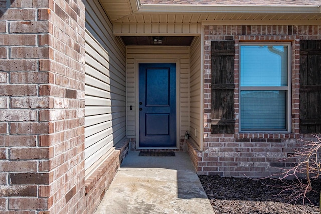 entrance to property with brick siding and roof with shingles