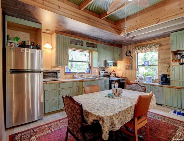 kitchen with light wood finished floors, light countertops, appliances with stainless steel finishes, and green cabinetry