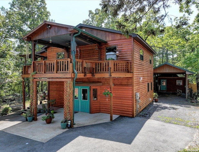 view of front of house featuring aphalt driveway and log veneer siding