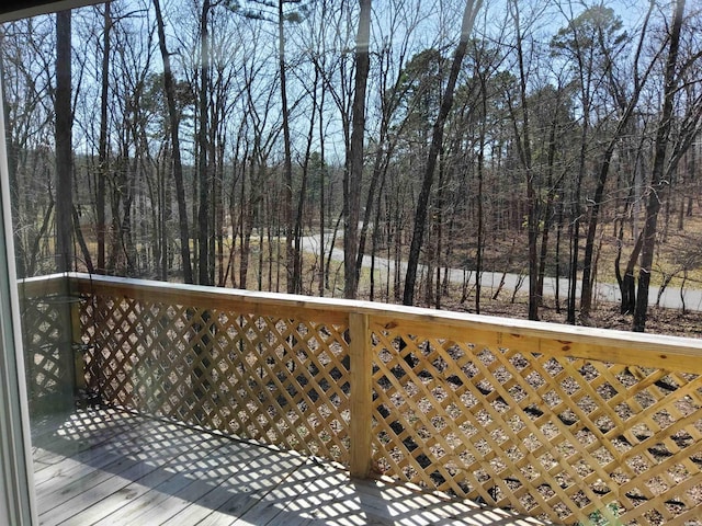 wooden terrace featuring a view of trees