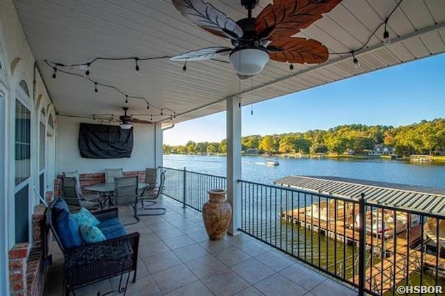 balcony with ceiling fan, a water view, and a sunroom