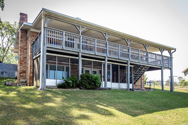 back of property with a wooden deck, a chimney, stairway, and a yard