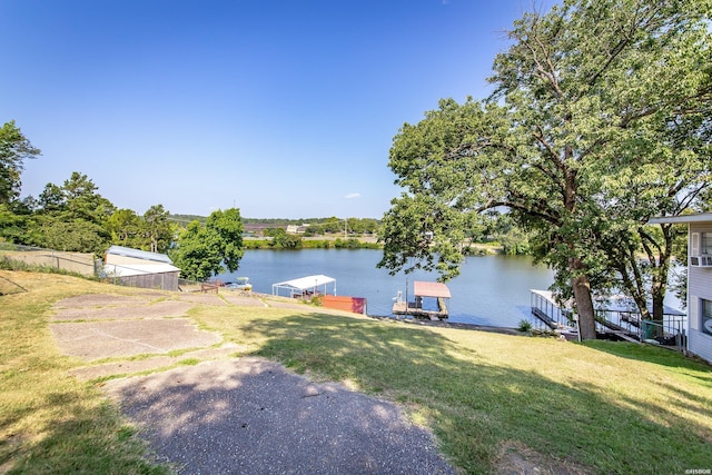 view of yard featuring a dock, a water view, and fence