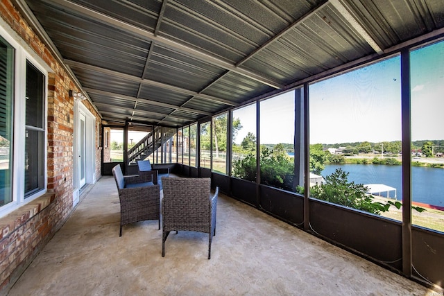 unfurnished sunroom featuring a water view