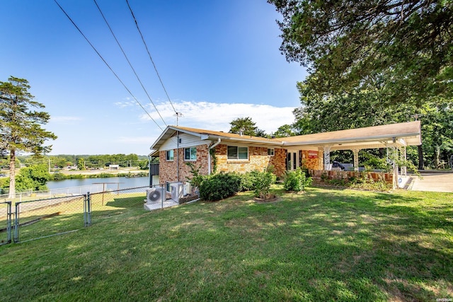 ranch-style house featuring a water view, fence, ac unit, a front yard, and brick siding