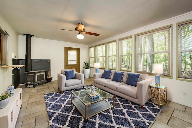 living room featuring a ceiling fan and a wood stove