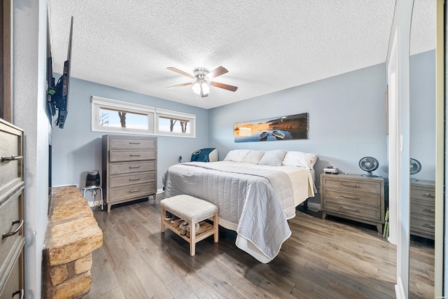 bedroom featuring ceiling fan, a textured ceiling, and wood finished floors