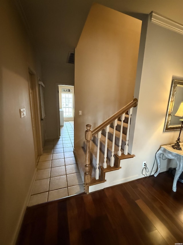 staircase featuring wood finished floors, visible vents, and baseboards