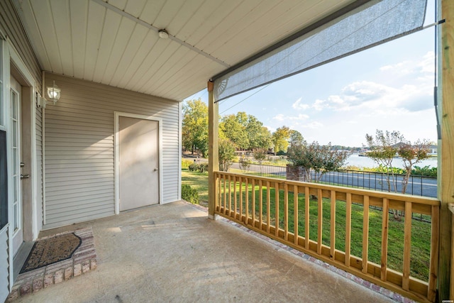 view of patio / terrace with a water view and fence