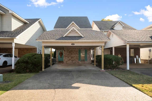 exterior space featuring driveway, roof with shingles, an attached carport, and brick siding