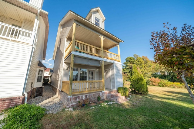 rear view of house featuring a yard and a balcony