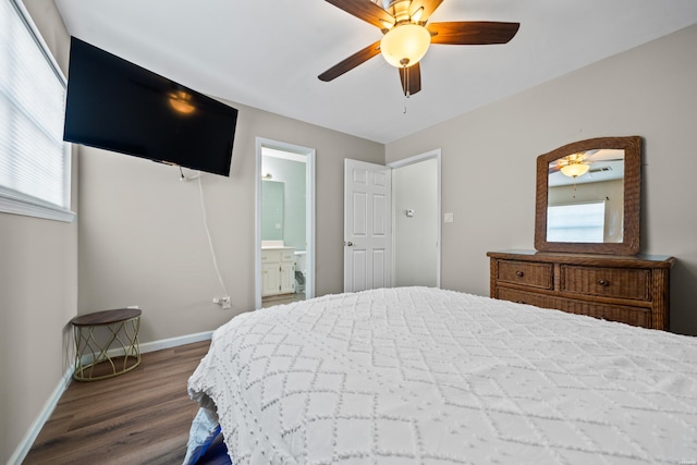 bedroom with dark wood-style floors, multiple windows, baseboards, and ensuite bathroom