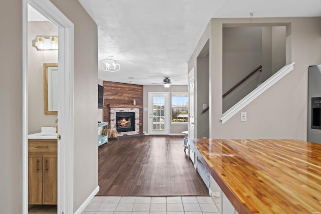 hall with stairway, a sink, and light tile patterned flooring