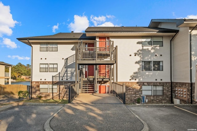 exterior space featuring brick siding, fence, and stairway