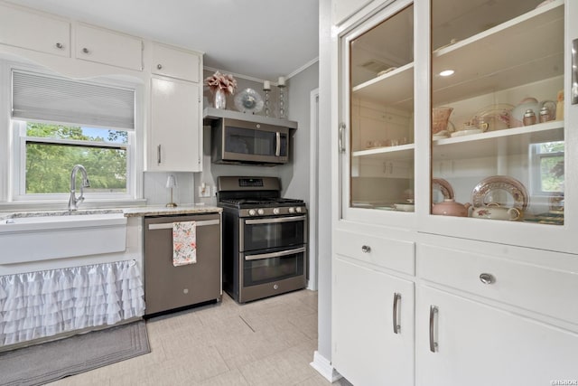 kitchen featuring ornamental molding, a sink, white cabinets, and stainless steel appliances