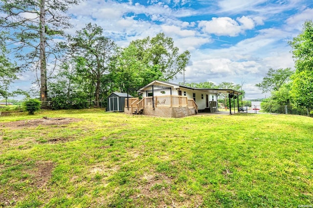 view of yard with a deck, fence, an outdoor structure, and a shed