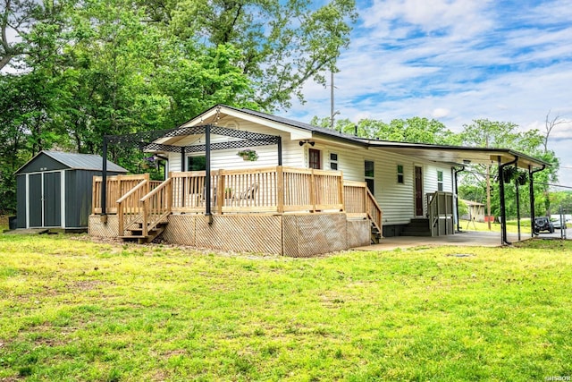 rear view of house with an outdoor structure, a deck, a yard, and a storage unit