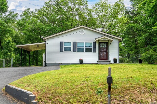 view of front of house with fence, a front yard, aphalt driveway, and crawl space